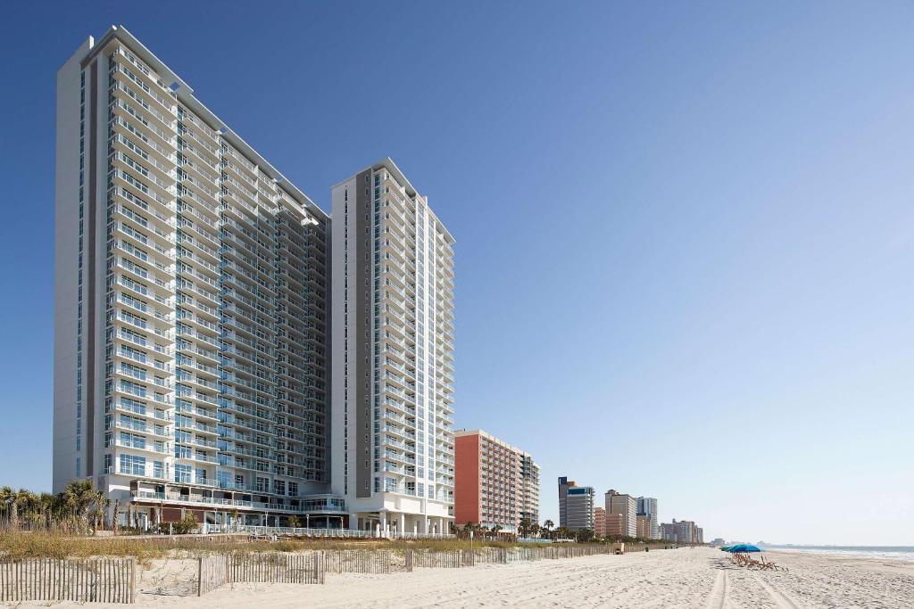 dwa wysokie budynki na plaży nad oceanem w obiekcie Hilton Grand Vacations Club Ocean Enclave Myrtle Beach w mieście Myrtle Beach