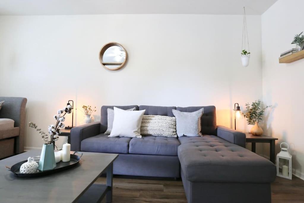 a living room with a blue couch and a table at Stylish & Renovated Modern Farmhouse Boutique Apt in Gainesville