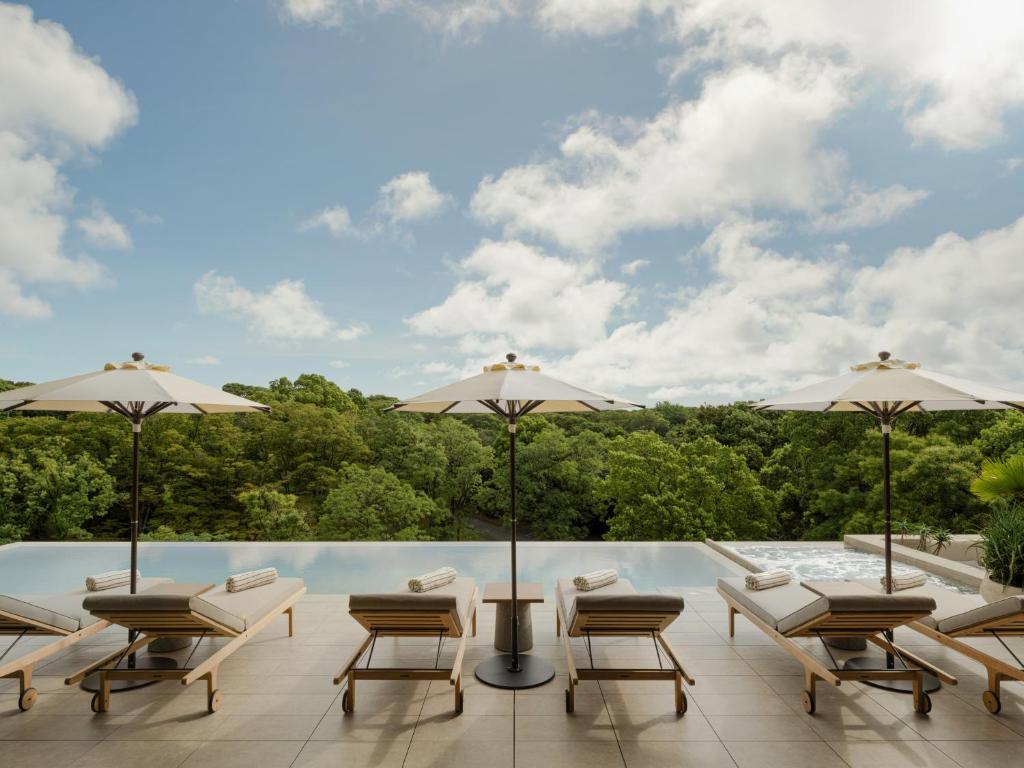 un patio con sillas y sombrillas y una piscina en TRUNK(HOTEL) YOYOGI PARK, en Tokio