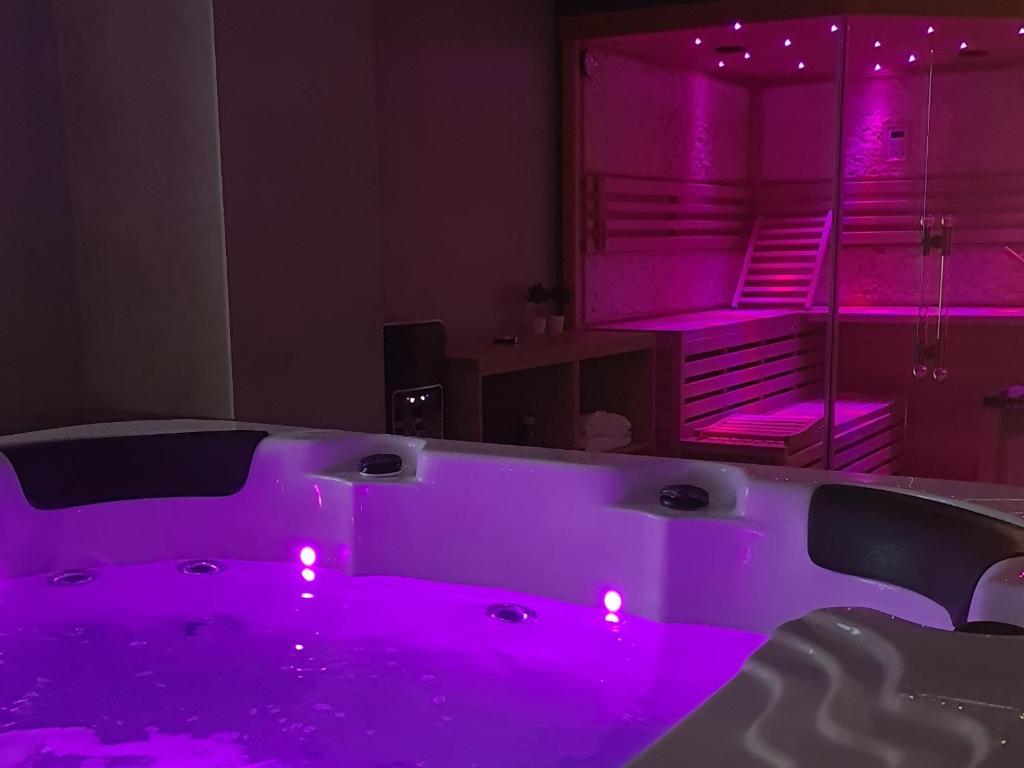 a bath tub with purple lights in a room at Luxury wellness apartment SHA in Osijek