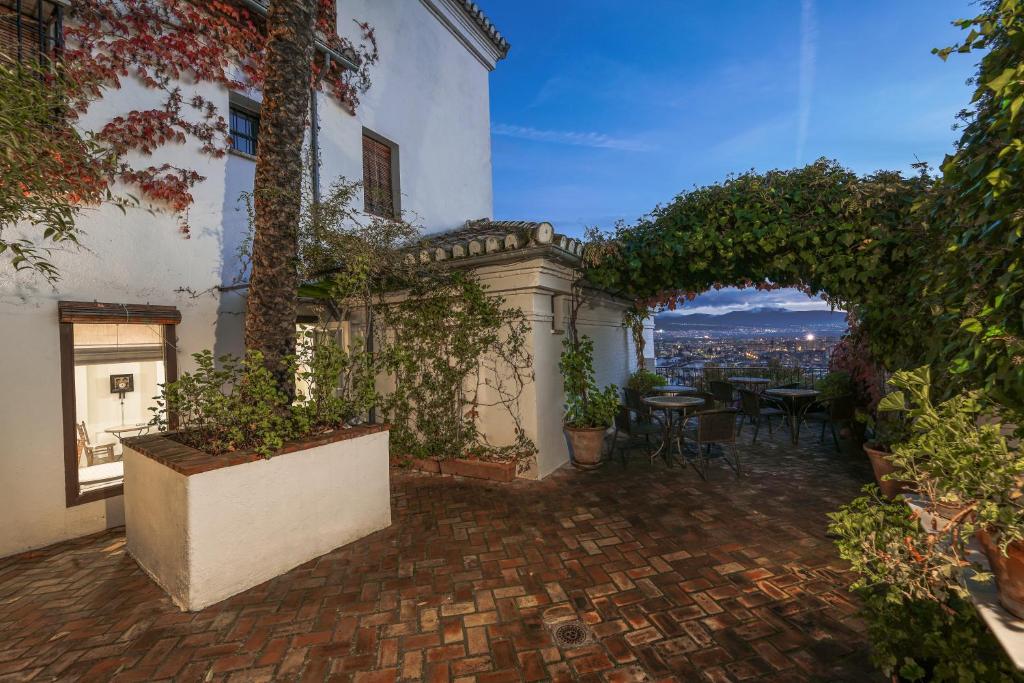 un patio avec une table et des chaises dans un bâtiment dans l'établissement Carmen de la Alcubilla del Caracol, à Grenade