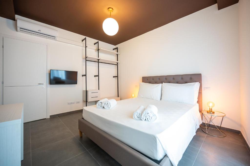 een slaapkamer met een groot wit bed met 2 kussens bij Porta Nuova Luxury Apartments in Turijn