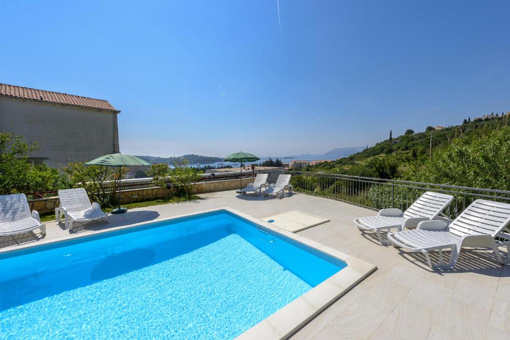 einen Pool mit Liegen und Stühlen auf dem Balkon in der Unterkunft Guest House Villa Bellevue in Cavtat