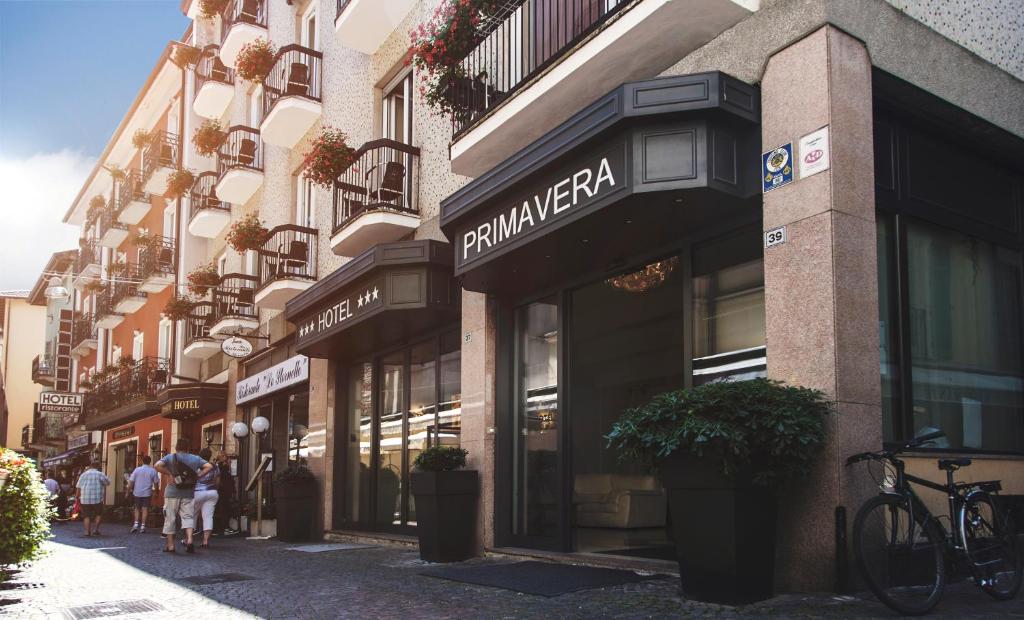 people walking down a street in front of a store at Primavera in Stresa