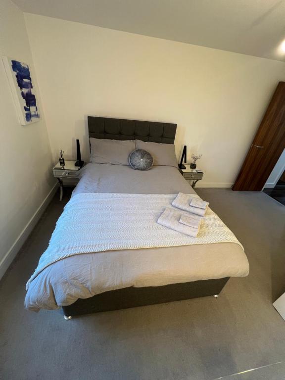 ein Schlafzimmer mit einem großen Bett mit zwei Tischen in der Unterkunft Perfect-City Centre-Apartment in Birmingham