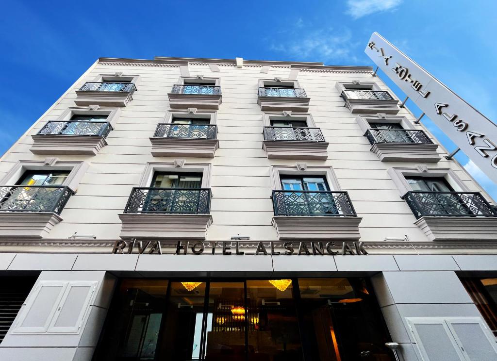 a white building with a sign on the front of it at Riva Hotel Alsancak in İzmir