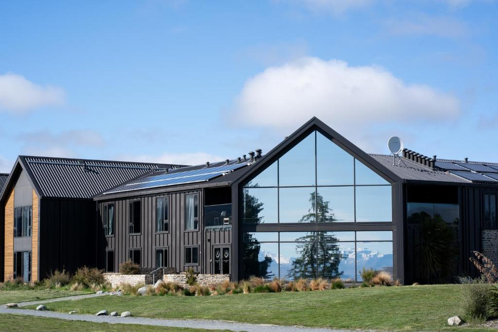 a large black building with glass windows at Haka House Lake Tekapo in Lake Tekapo