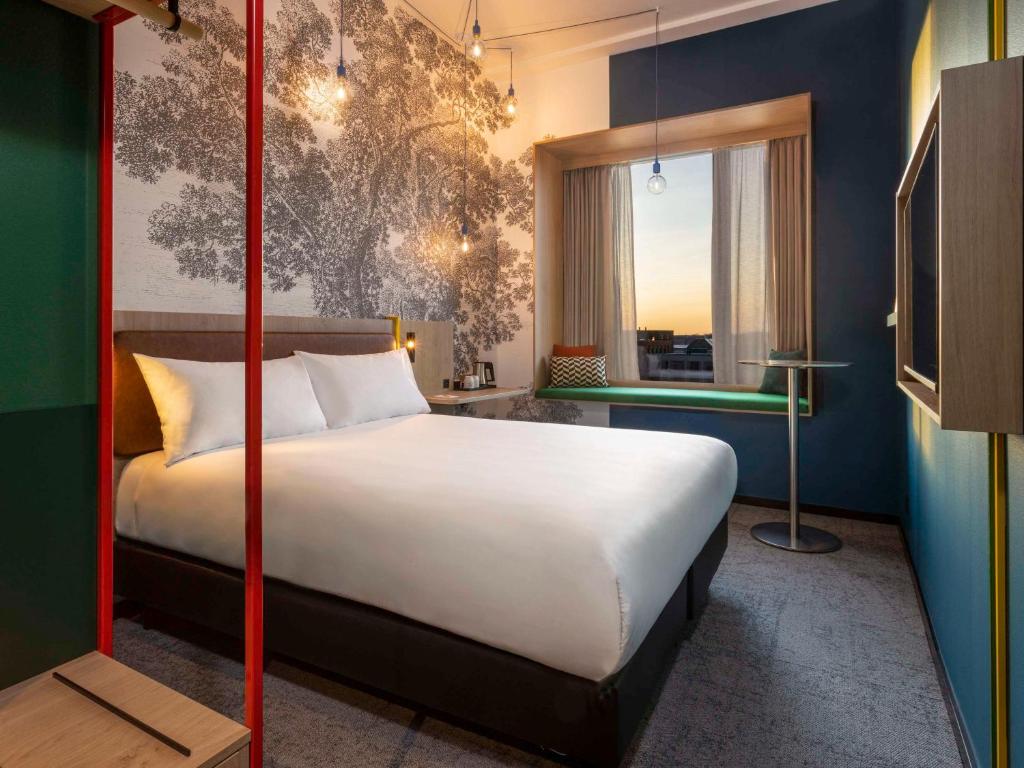 een slaapkamer met een groot wit bed en een raam bij ibis Styles Copenhagen Orestad in Kopenhagen