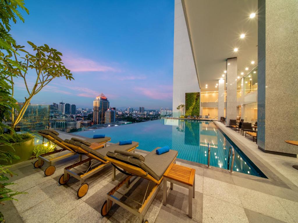 a pool with lounge chairs and a view of the city at Sunway Sanctuary - Seniors Hotel & Residences in Subang Jaya