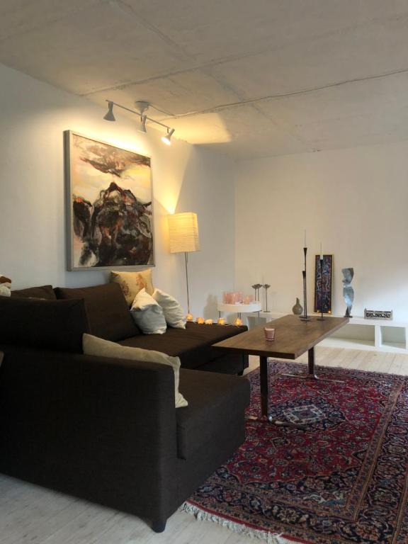 ein Wohnzimmer mit einem Sofa und einem Tisch in der Unterkunft AppleFlower Farm retro apartment in Lillerød