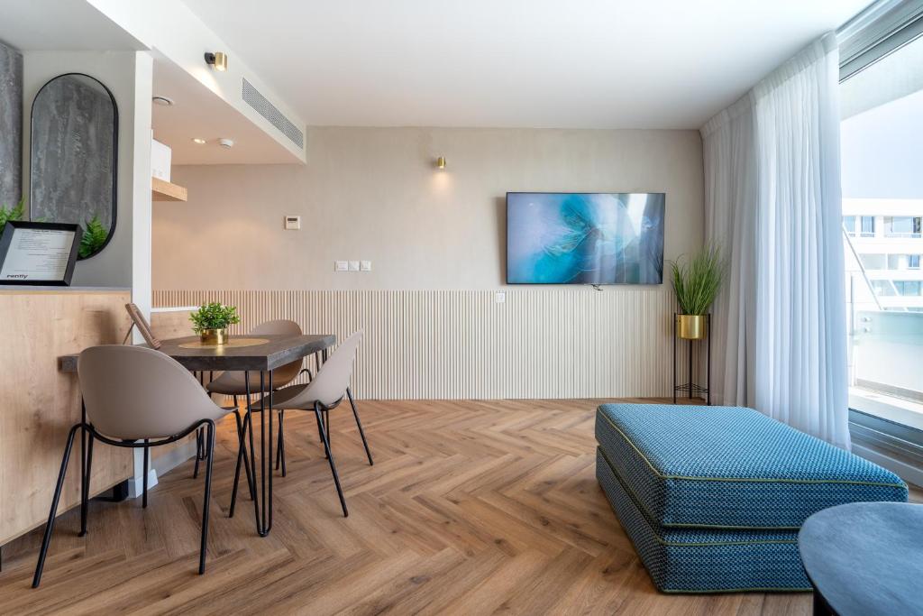 uma sala de estar com uma mesa e cadeiras e uma cama em Luxury Apartments - By Harim em Eilat