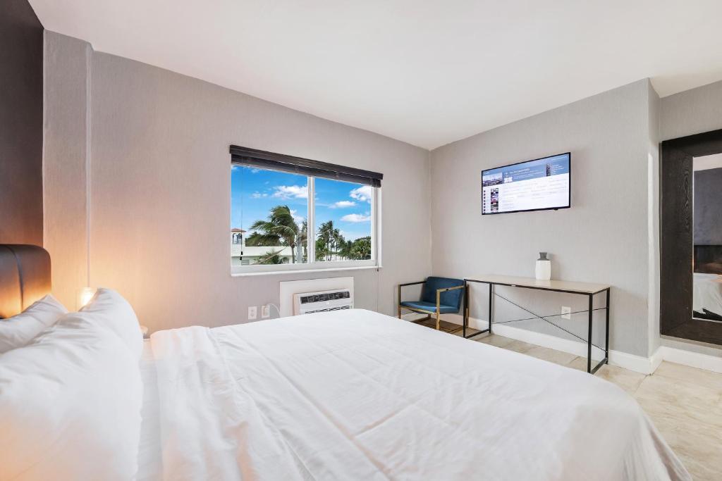 a bedroom with a white bed and a window at Starlite Hotel in Miami Beach