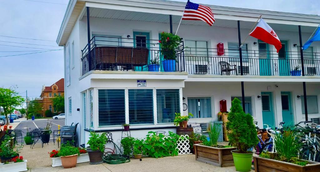 een wit huis met een Amerikaanse vlag op een balkon bij Hotel on Magnolia East 'HOME' in Wildwood