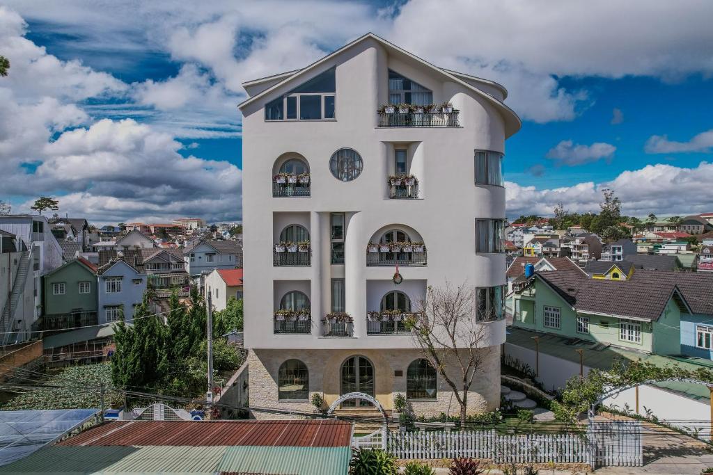 Un bâtiment blanc avec une horloge. dans l'établissement Jodi Dalat Hotel, à Đà Lạt