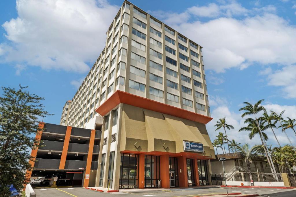 ein hohes Bürogebäude mit einem Gebäude in der Unterkunft Best Western The Plaza Hotel Honolulu Airport - Free Breakfast in Honolulu