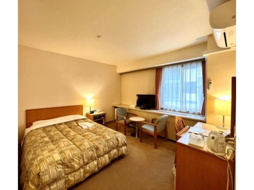 千叶Hotel Tetora Makuhari Inagekaigan - Vacation STAY 91492v的配有一张床和一张书桌的酒店客房