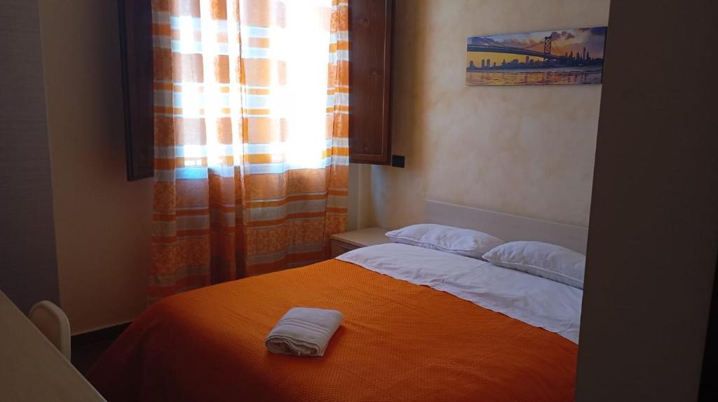 a bedroom with a bed with two towels on it at T'Addormento in Reggio di Calabria