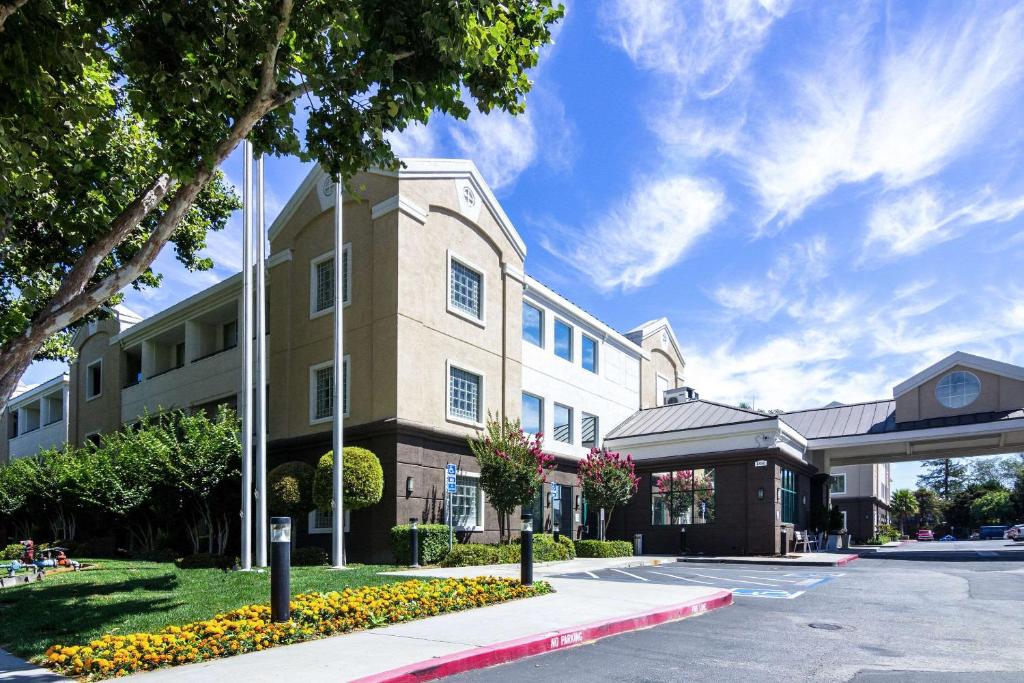 Country Inn & Suites by Radisson, San Jose International Airport, CA في سان خوسيه: مبنى على شارع بجانب موقف سيارات