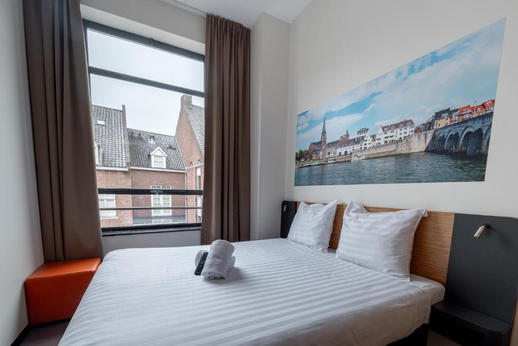 ein Schlafzimmer mit einem Bett und einem großen Fenster in der Unterkunft easyHotel Maastricht City Centre in Maastricht