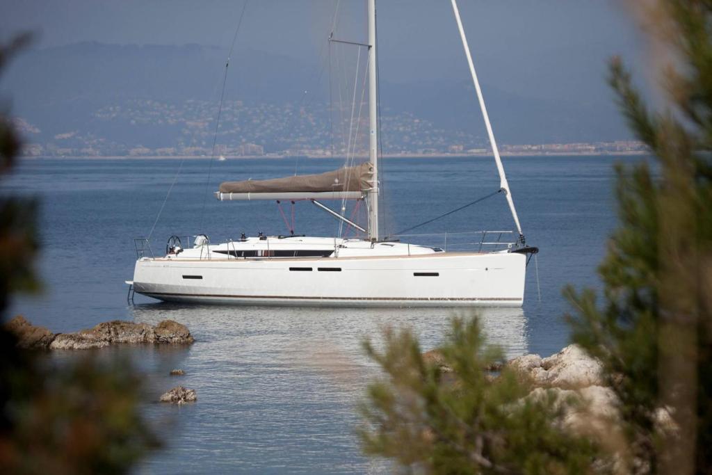 a white sail boat sitting on the water at Sleep aboard a modern sailboat in Oeiras in Oeiras