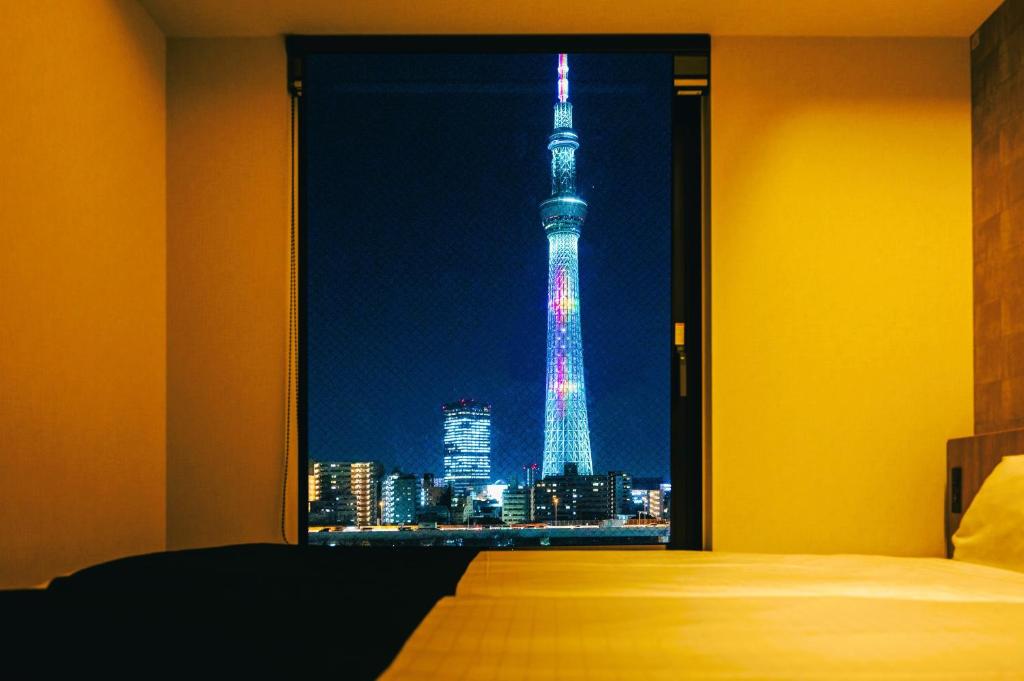 - une chambre avec vue sur la tour Eiffel la nuit dans l'établissement stayme THE HOTEL Asakusa Riverside, à Tokyo