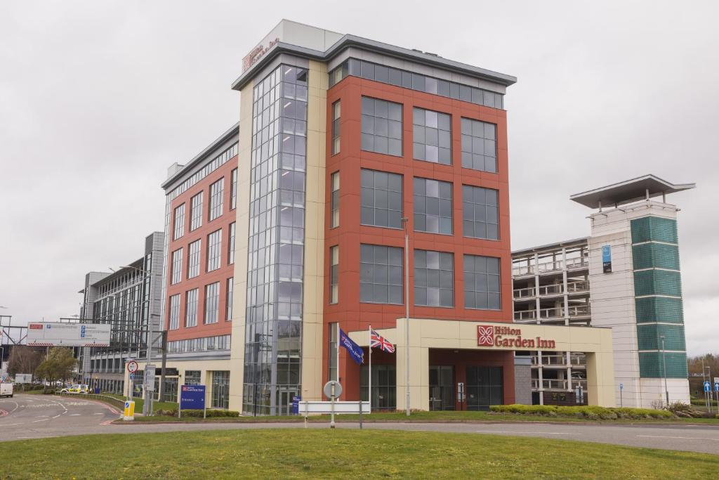 Hilton Garden Inn Birmingham Airport Uk في بيكينهيل: مبنى احمر طويل امام شارع