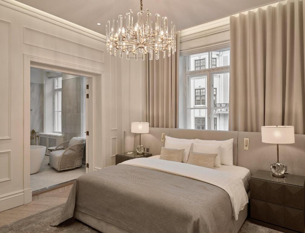 a bedroom with a large bed and a chandelier at The Hotel Maria - Preferred Hotels & Resorts in Helsinki