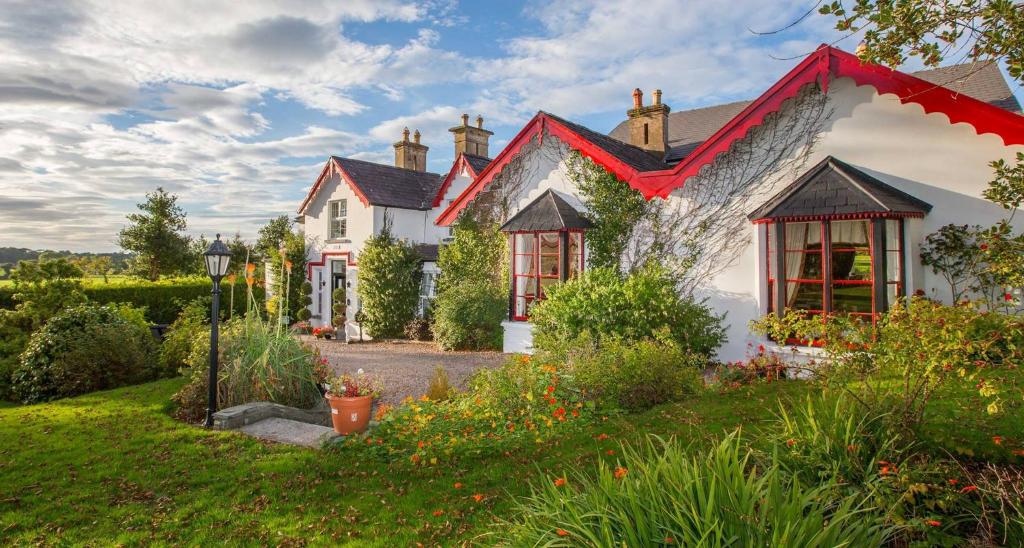 uma casa branca com um telhado vermelho em Killeen House Hotel em Killarney