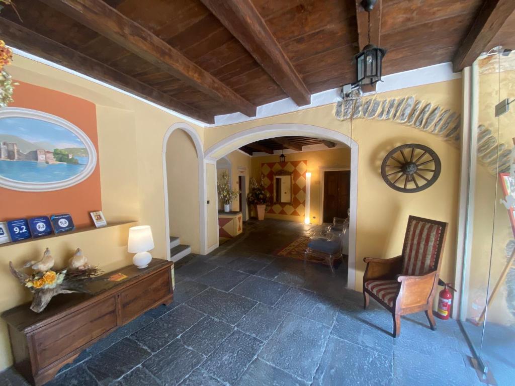 uma sala de estar com uma cadeira e um relógio na parede em Hotel Casa Arizzoli em Cannobio