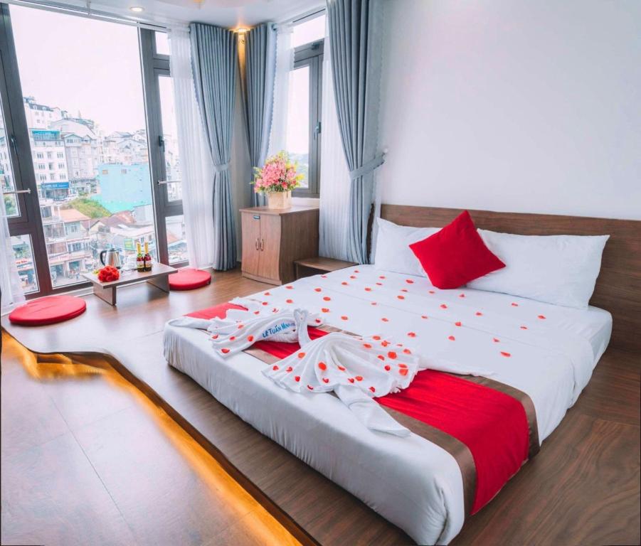 - une chambre dotée d'un grand lit avec des draps rouges et blancs dans l'établissement Le Tuan Minh Hotel, à Đà Lạt