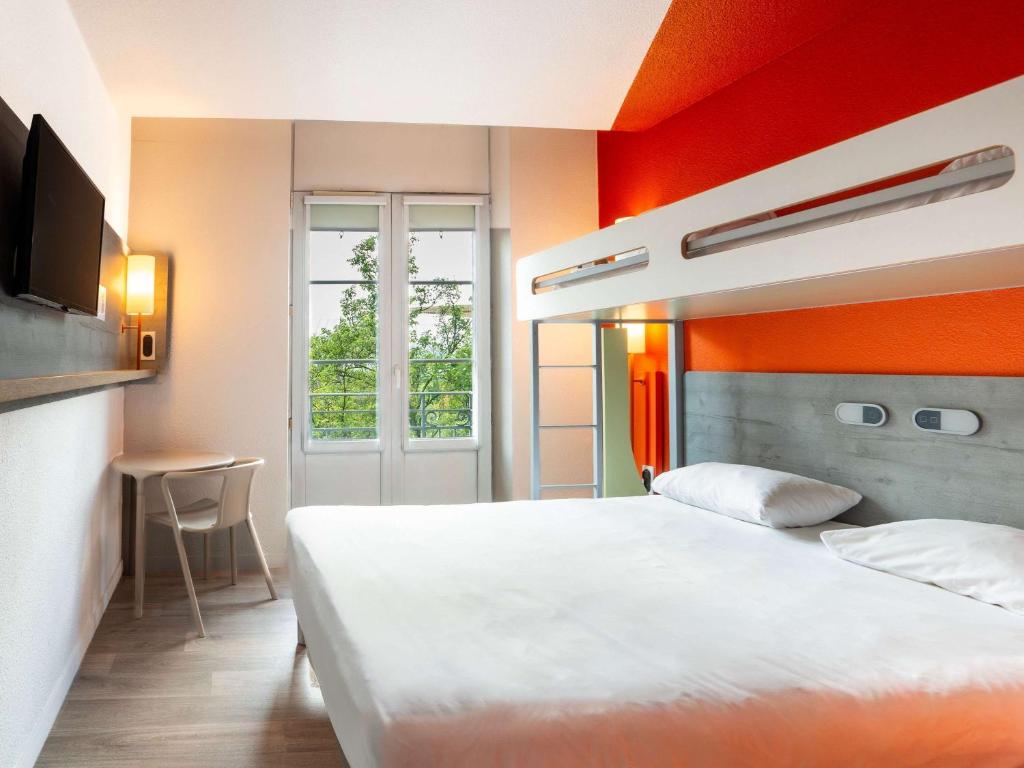 a bedroom with a white bed and an orange wall at Ibis Budget Strasbourg Centre Gare in Strasbourg