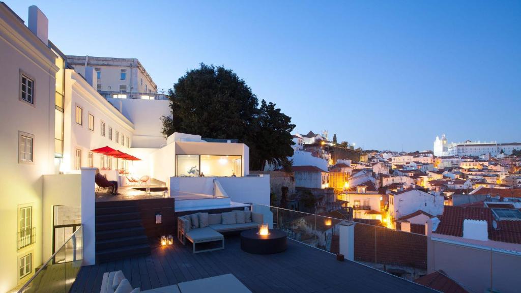 a balcony with a view of a city at night at Memmo Alfama - Design Hotels in Lisbon