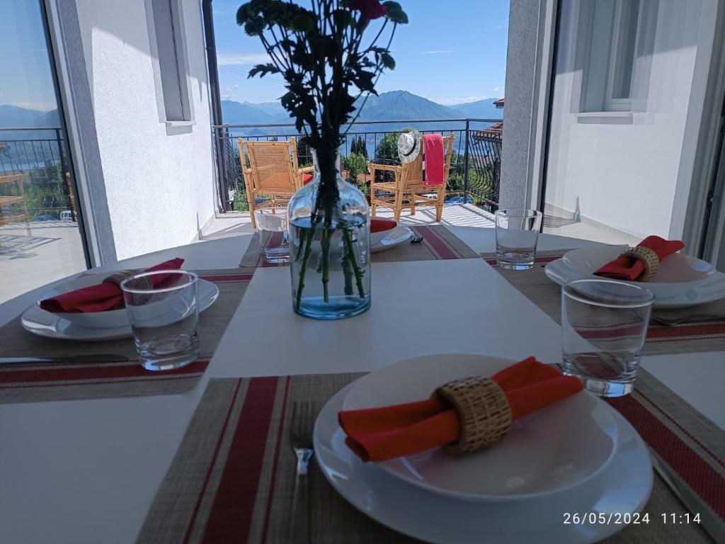 une table avec des assiettes de nourriture et un vase avec des fleurs dans l'établissement Appartamenti Luna - Stresa, à Stresa