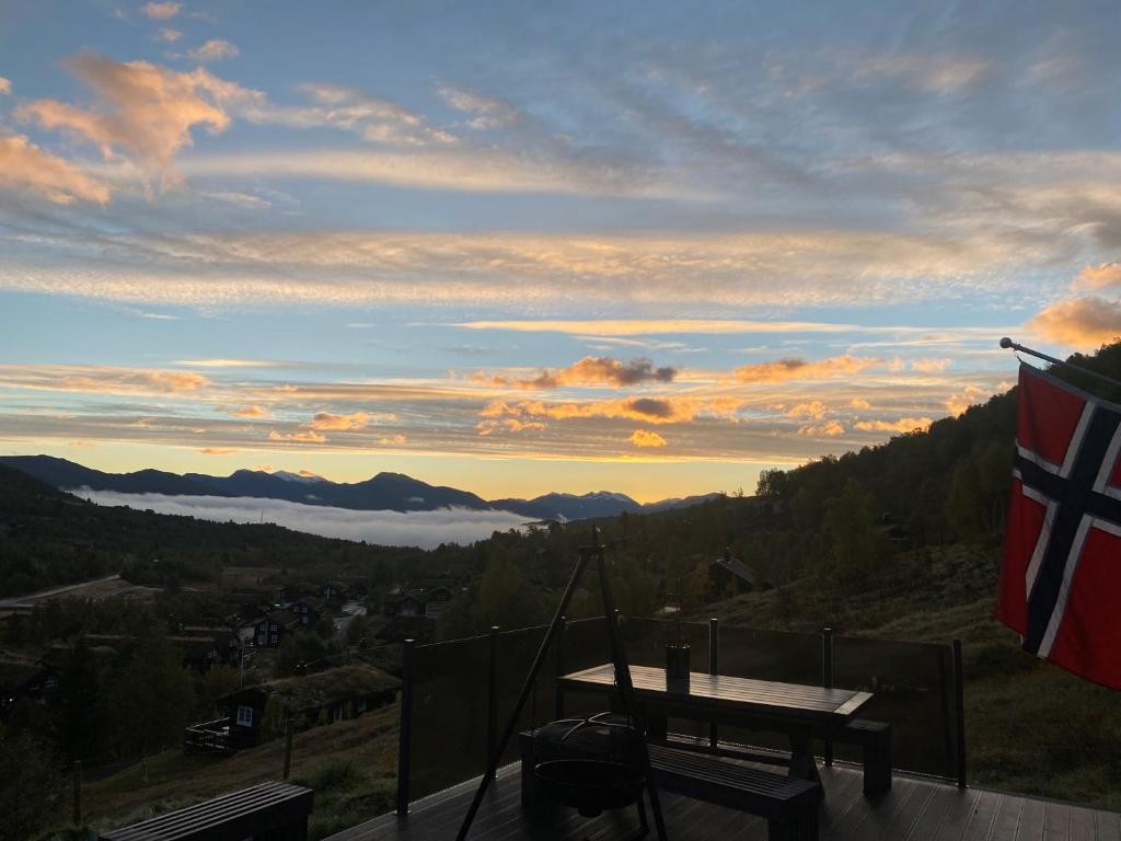 einen Blick auf die Berge mit einem Tisch und einer Flagge in der Unterkunft Hytte med god standard in Stranda