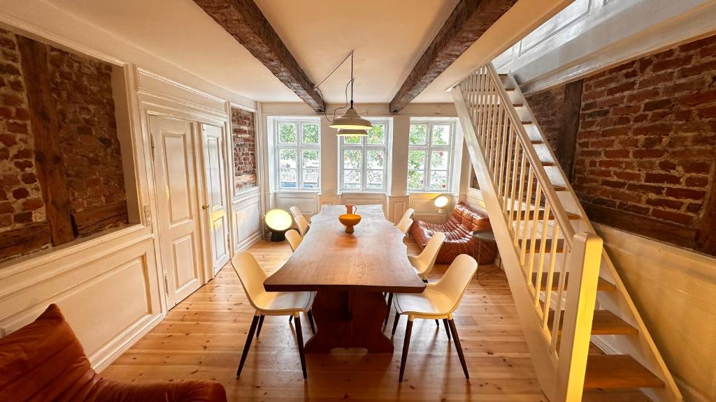 een eetkamer met een tafel en stoelen en een trap bij Beautiful Townhouse in Kopenhagen