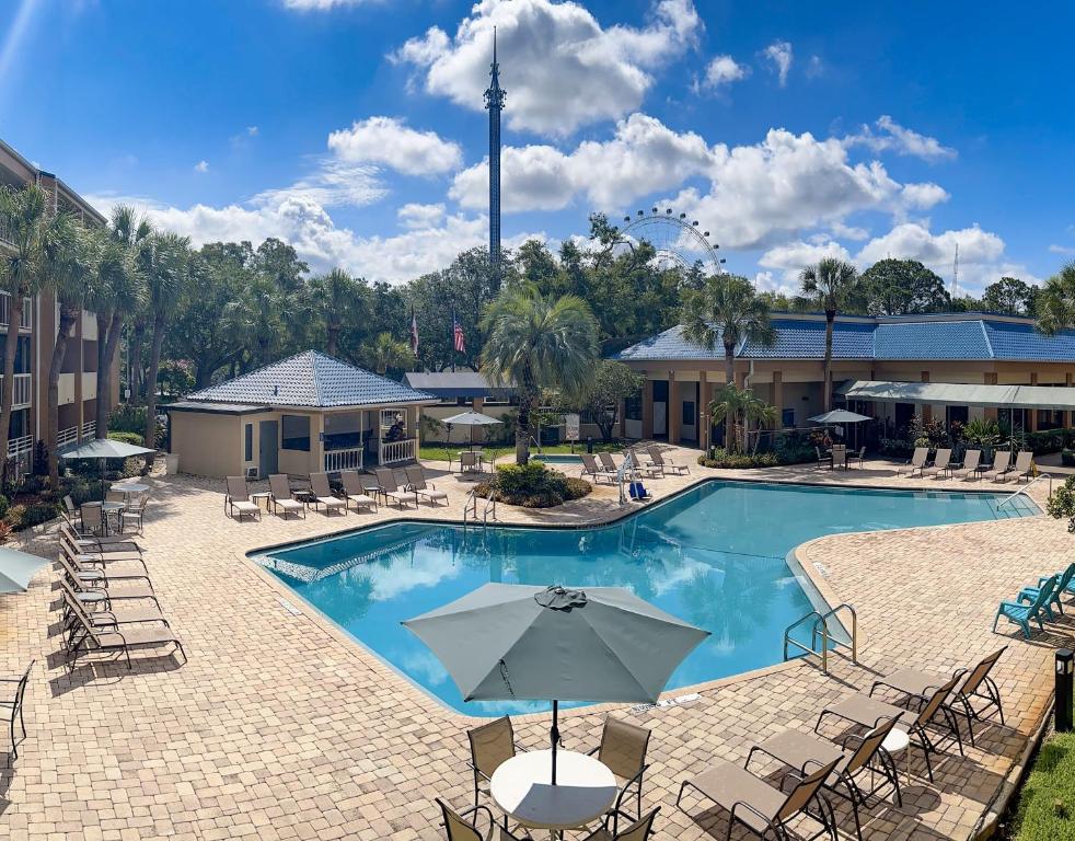 a pool at a hotel with chairs and an umbrella at Hotel SonoHotel By Monreale IDrive in Orlando