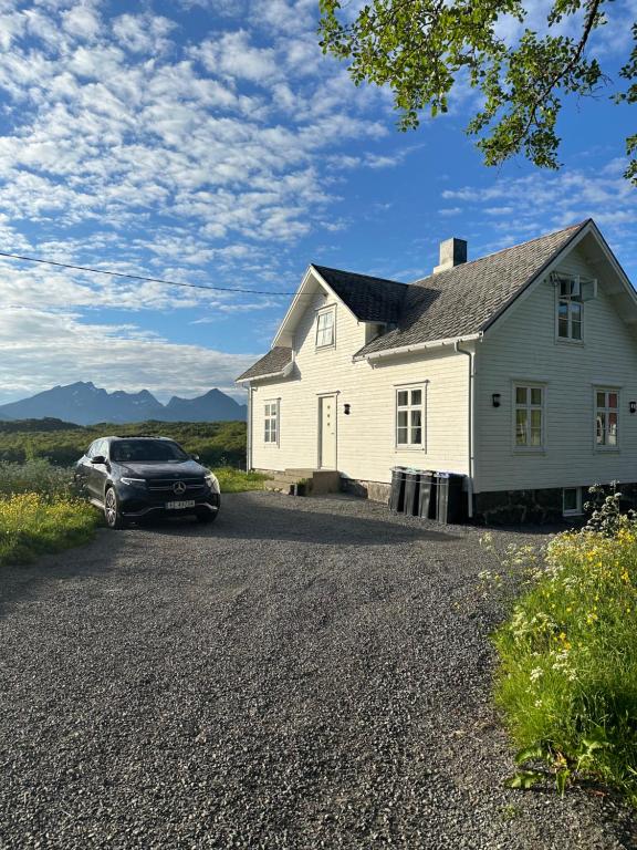 ein Auto, das vor einem weißen Haus parkt in der Unterkunft Nordlandshus Lofoten 