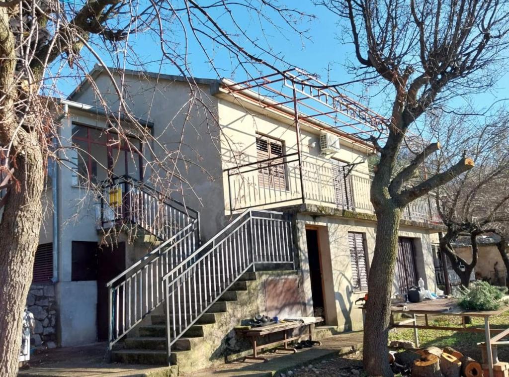 une maison blanche avec des escaliers et une terrasse couverte dans l'établissement Holiday Home Marina, à Stari Grad