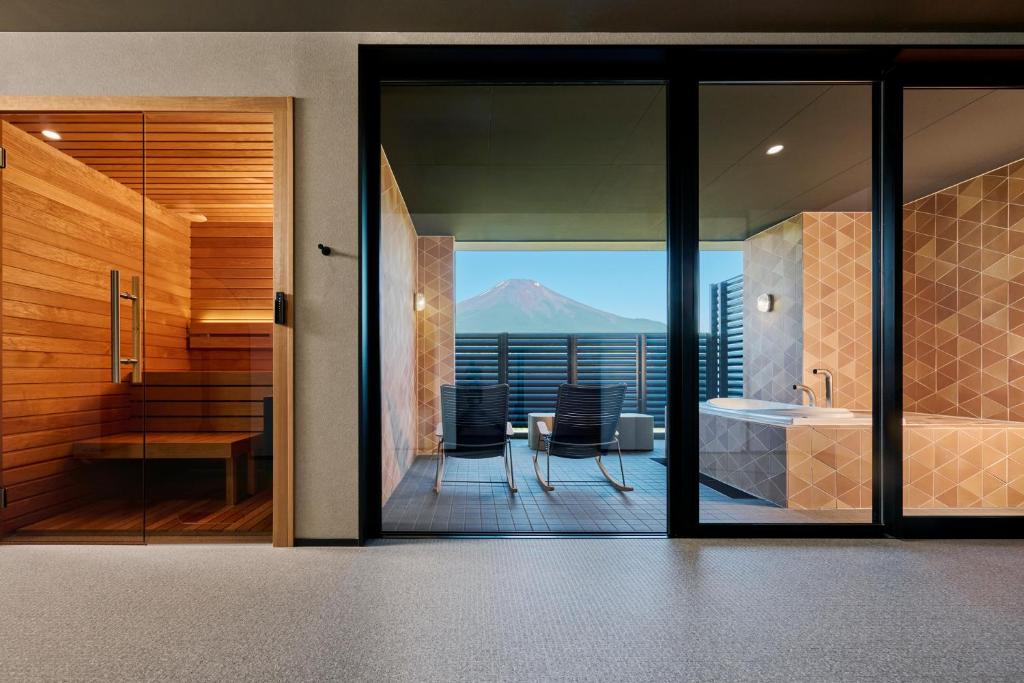 a bathroom with a view of a mountain through glass at Mt Fuji View and Private Sauna Ryokan Shizuku in Yamanakako