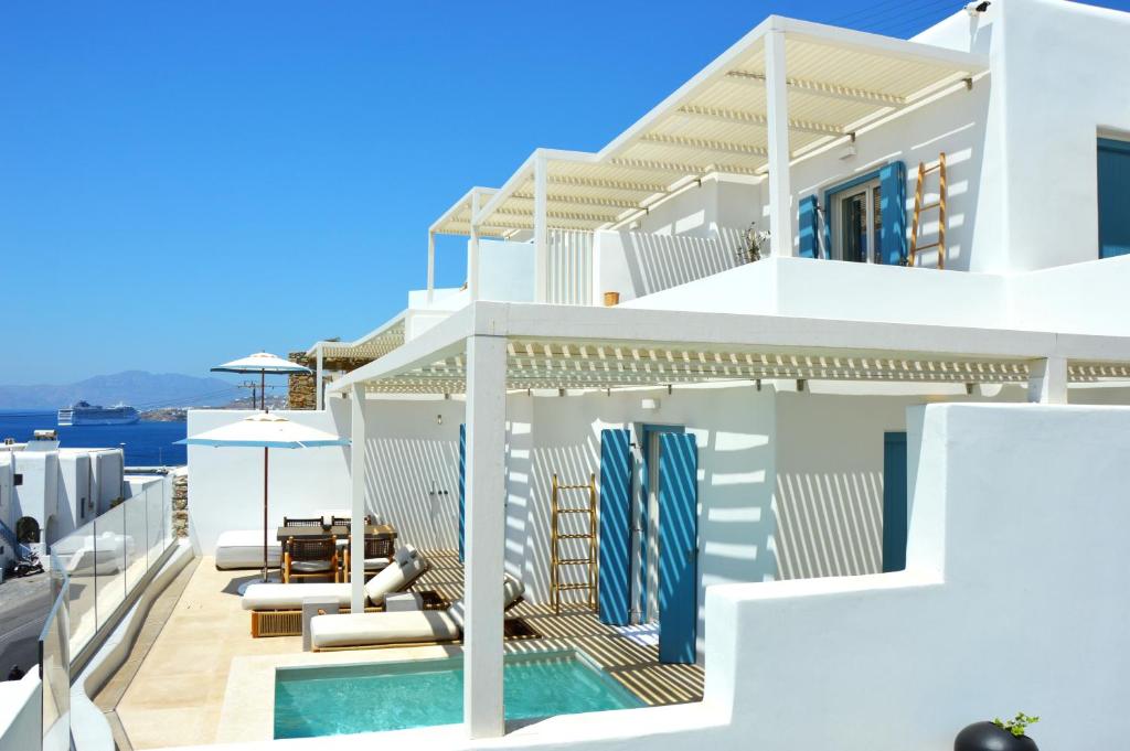 a white villa with a swimming pool and blue sky at Νumi Boutique Hotel in Mikonos