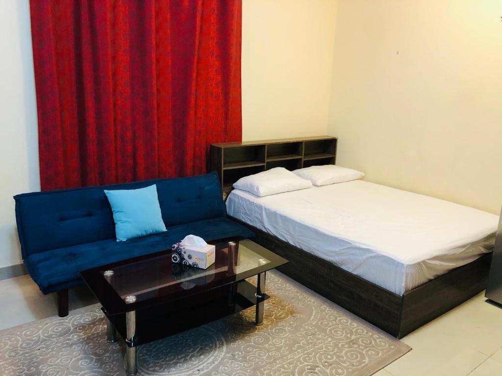 - une chambre avec un lit, un canapé et une table dans l'établissement Premium Furnished studio, à Charjah