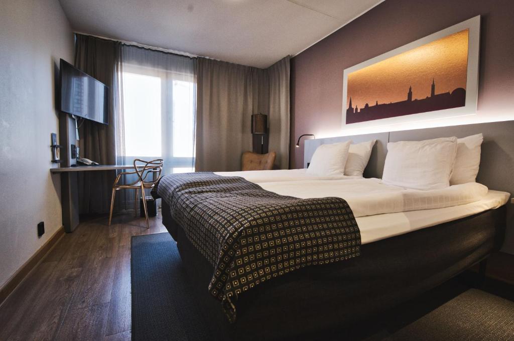 een hotelkamer met een groot bed en een bureau bij Hotel Birger Jarl in Stockholm