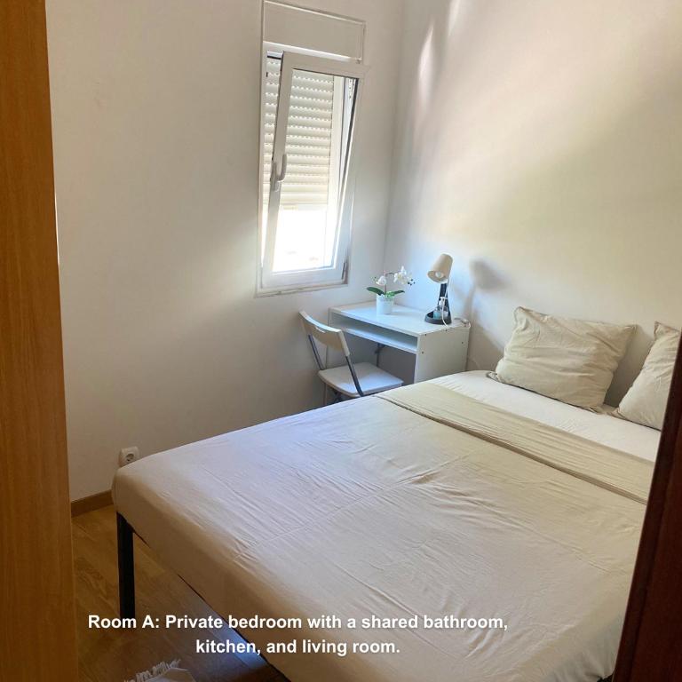 a bedroom with a bed and a desk with a window at Lisbon Airport Guesthouse in Lisbon