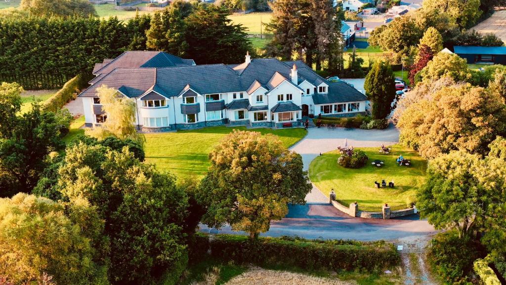 uma vista aérea de uma grande casa com um lago em Loch Lein Country House em Killarney