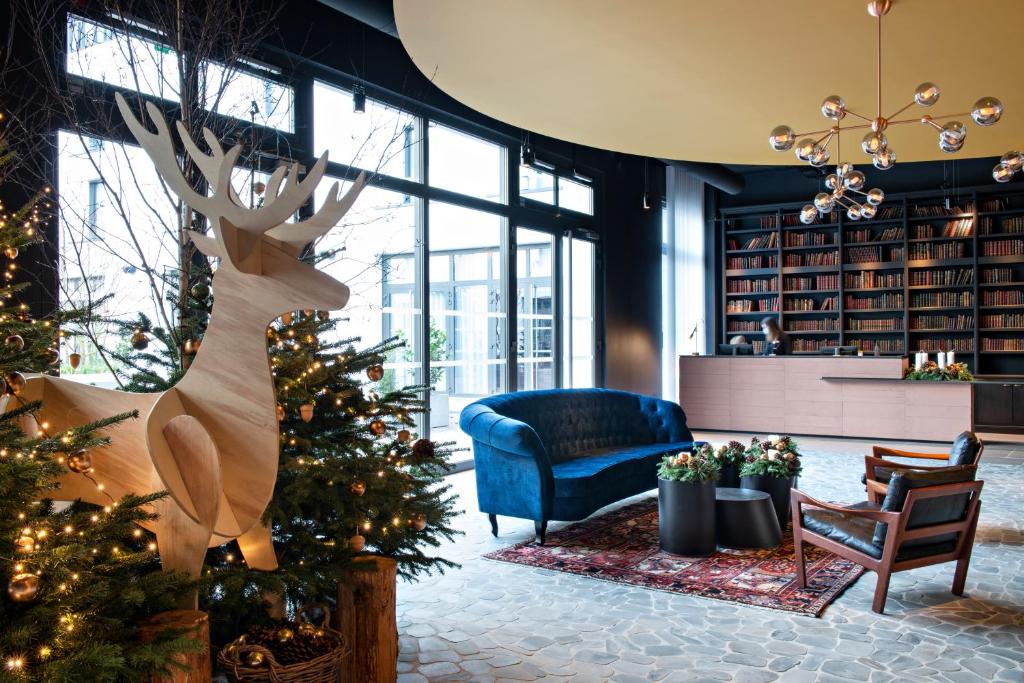 a library with a christmas tree and a blue chair at Hôtel LÉONOR the place to live in Strasbourg