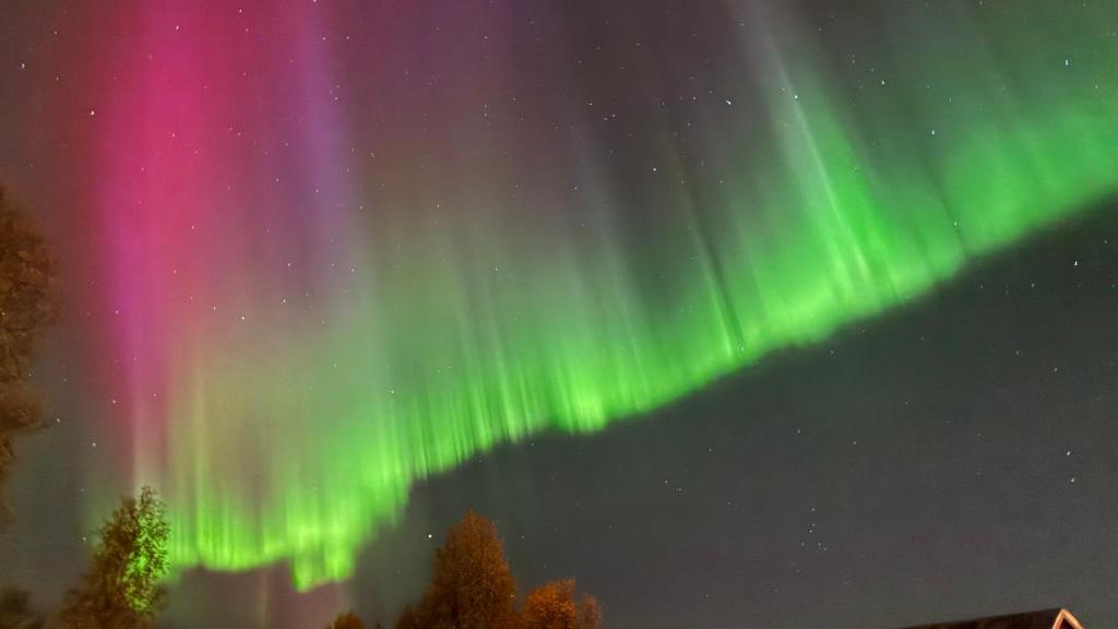 een afbeelding van het noorderlicht in de lucht bij Villa Arctica in Tromsø