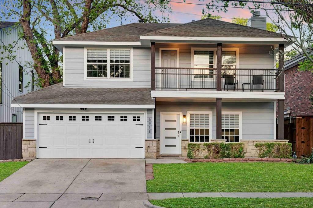 una casa blanca con una puerta de garaje blanca en Highland Cottage Central Huge Yard HOT TUB, en Dallas