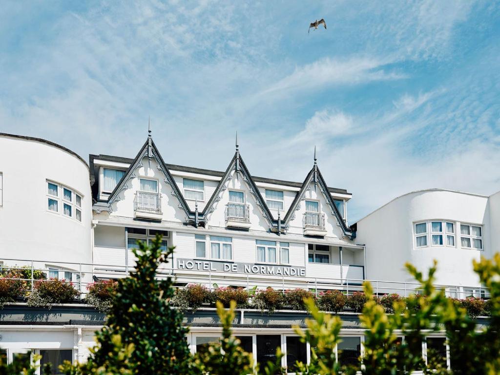 un grande edificio bianco con un aquilone nel cielo di Hotel De Normandie a Saint Helier Jersey