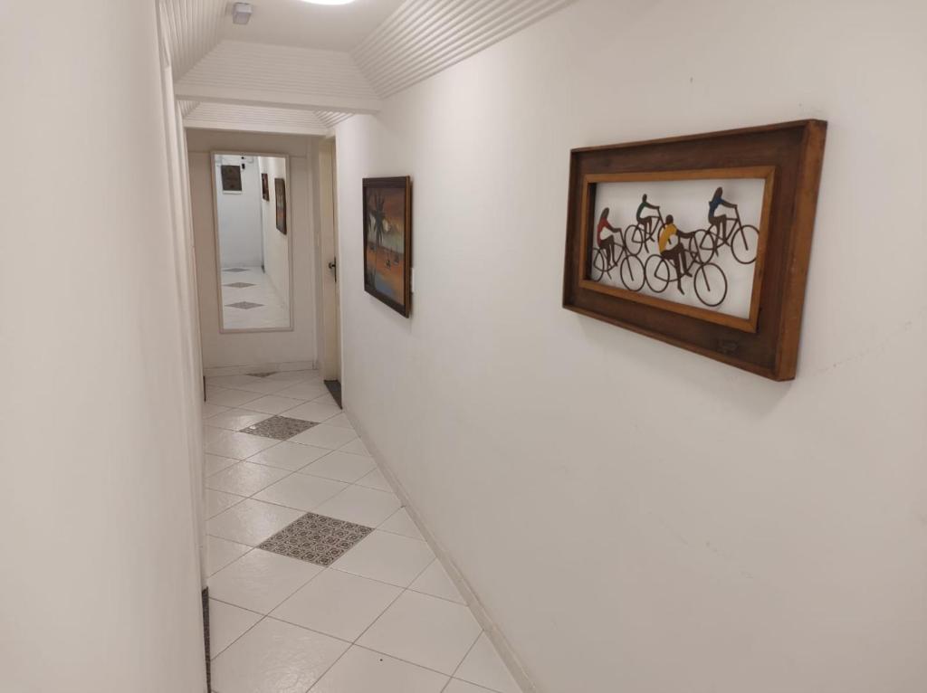 a hallway with paintings of bikes on the wall at Pousada Capua Buzios in Búzios