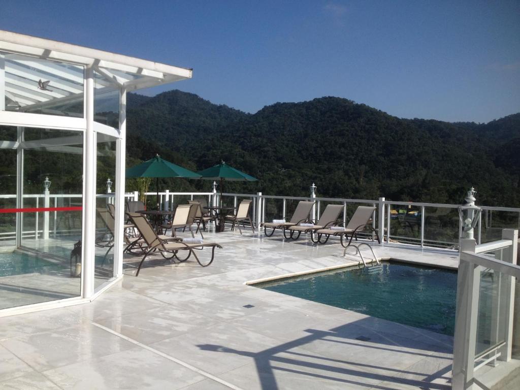 un patio con sillas y una piscina en la azotea en Pousada Terraço Penedo, en Penedo